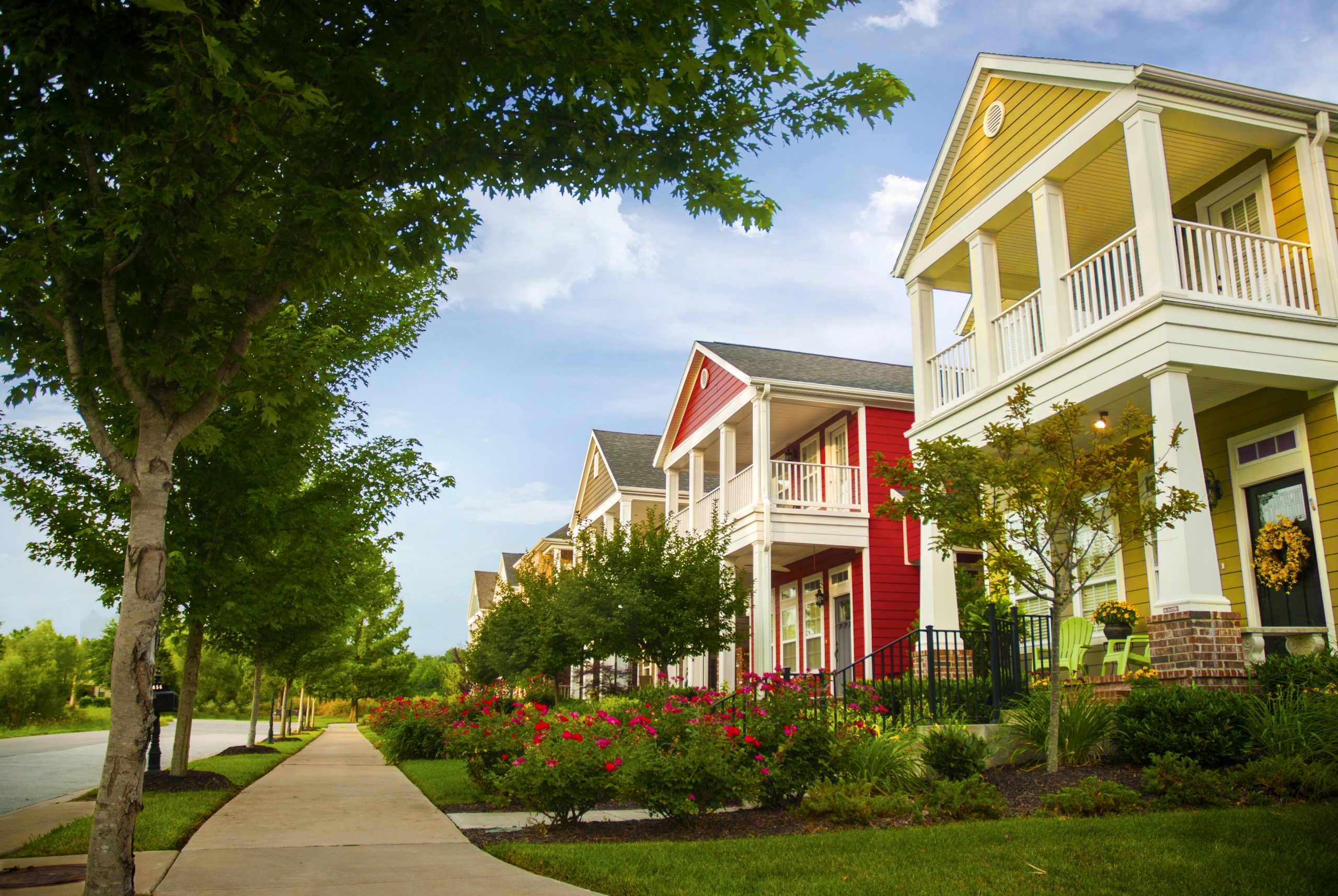 Row of colorful garden homes with two stories and white pillars in suburban neighborhood of Fayetteville, Arkansas