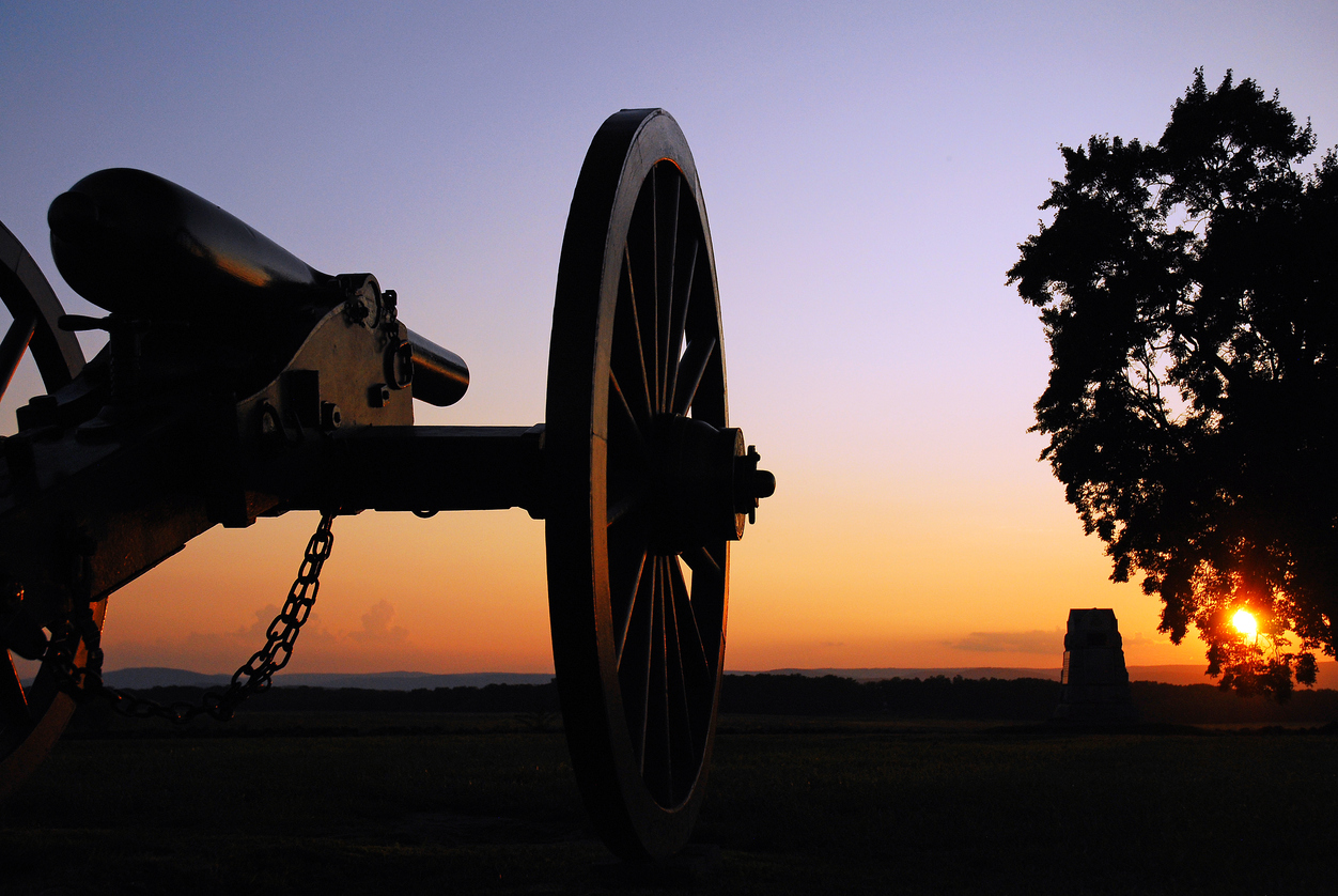 A cannon from the American Civil War sits silently at sunset at Gettysburg National Battlefield