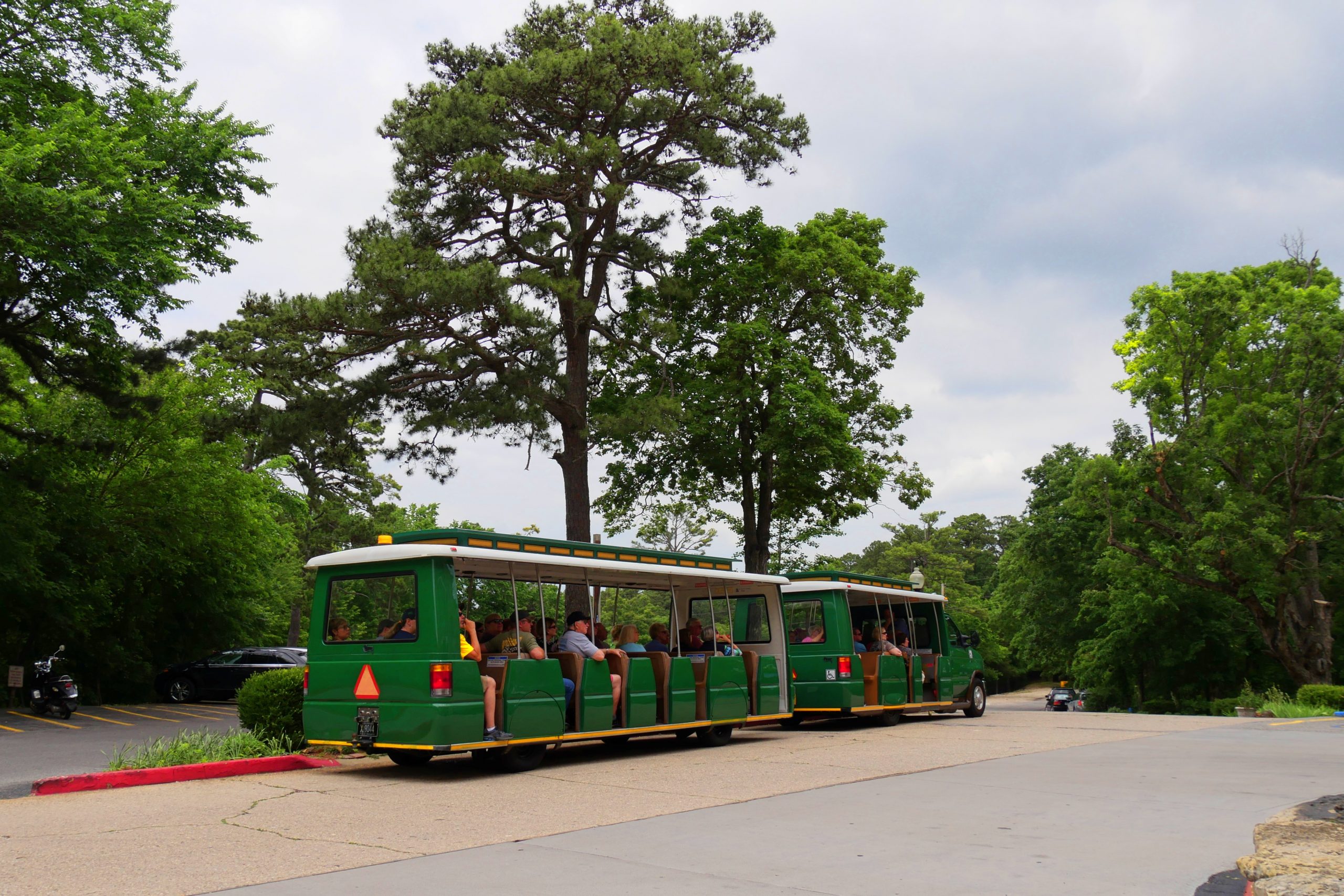 EUREKA SPRINGS, ARKANSAS—A green tram tours trolley with passengers runs around the historic district of of Eureka Springs. Taken in May 2017.