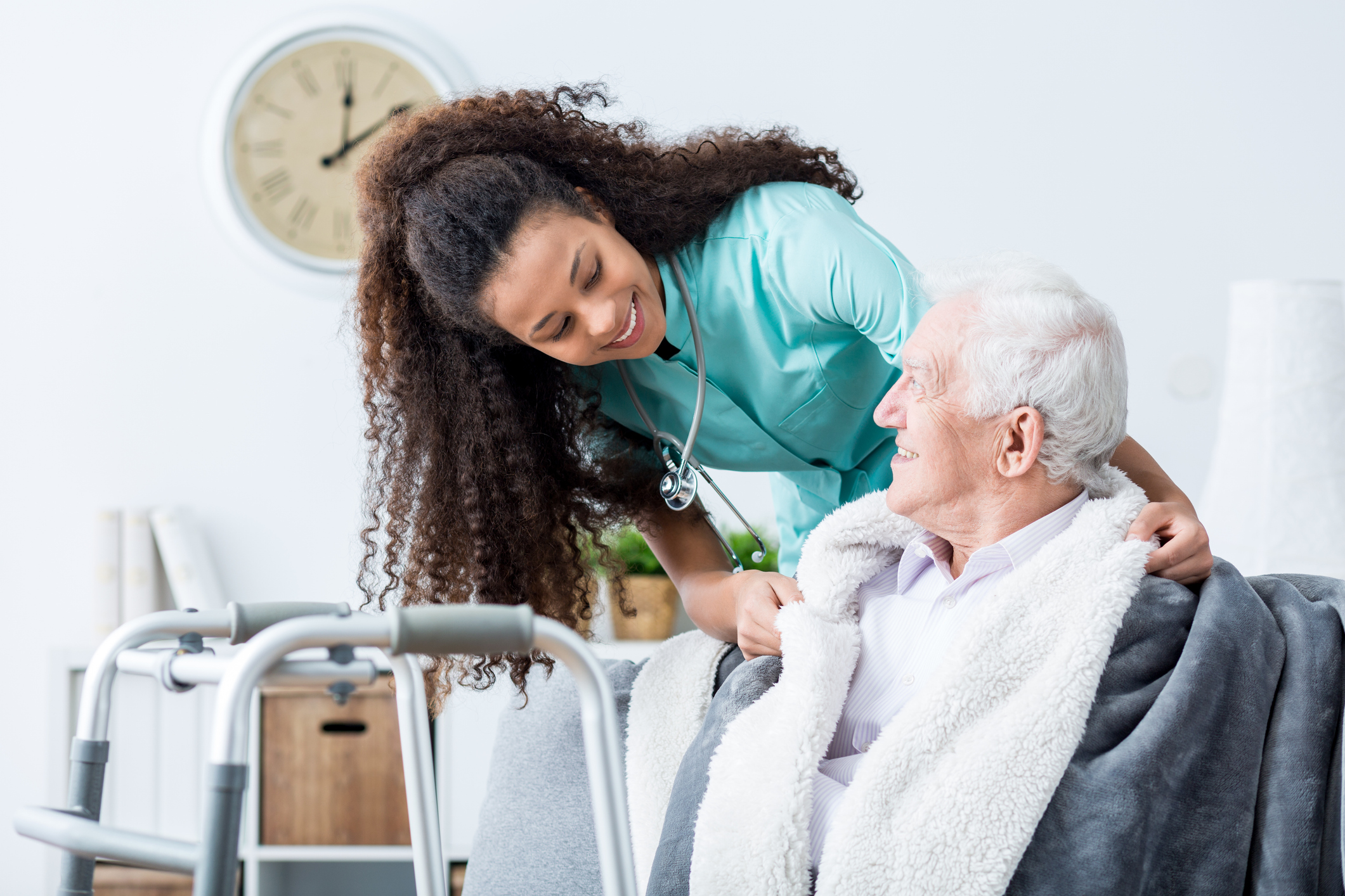 Smiling carer taking care of disabled senior man.